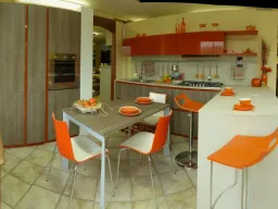 cucina isola centrale bianco arancio